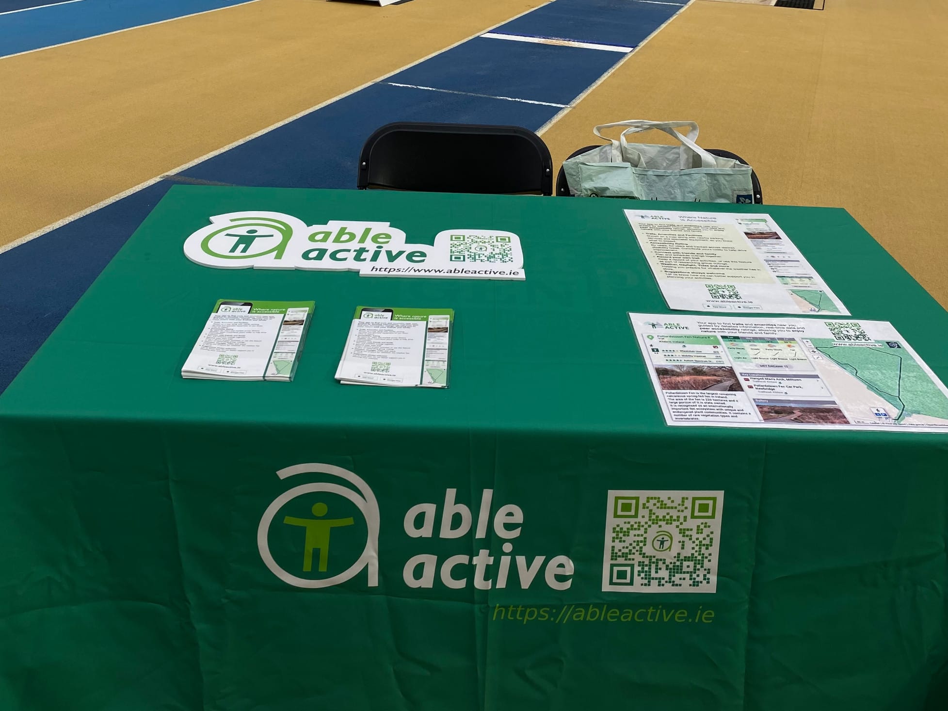Exhibitor table with branded tablecloth and flyers at the Sport Ireland National Indoor Arena